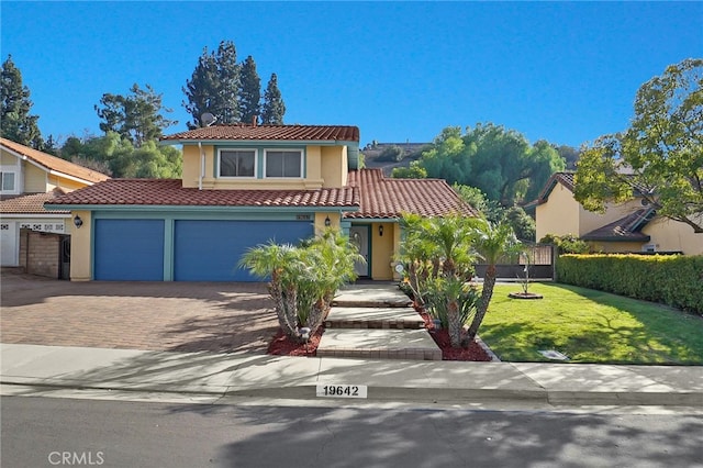 mediterranean / spanish-style house featuring a garage and a front yard