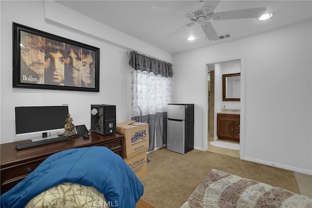 carpeted bedroom featuring ceiling fan, stainless steel refrigerator, and ensuite bathroom