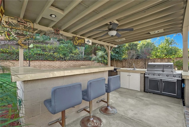 view of patio featuring grilling area, ceiling fan, area for grilling, and an outdoor wet bar