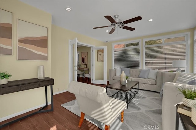 living room featuring ceiling fan and dark hardwood / wood-style floors