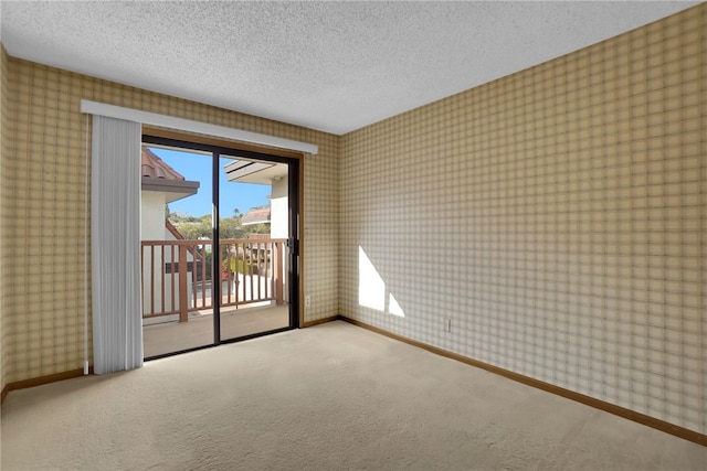 carpeted spare room featuring a textured ceiling