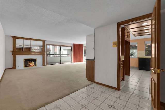 unfurnished living room featuring light carpet and a textured ceiling