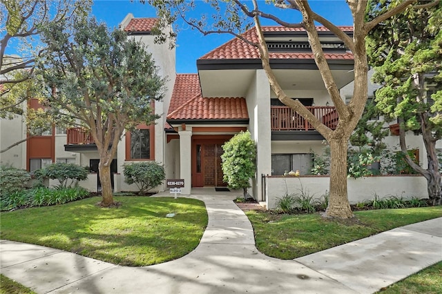 mediterranean / spanish-style house with a balcony and a front yard