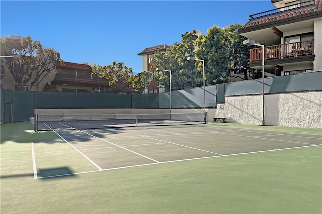 view of tennis court with basketball hoop