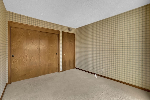 unfurnished bedroom with carpet and a textured ceiling