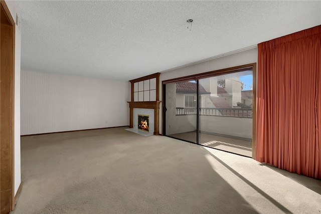 unfurnished living room featuring a large fireplace, a textured ceiling, and carpet flooring