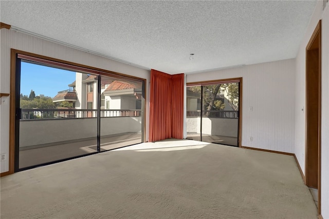 carpeted empty room with a textured ceiling