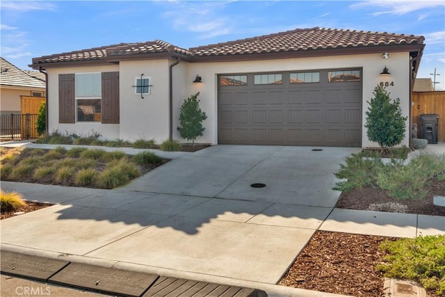 mediterranean / spanish-style home featuring a tile roof, driveway, and stucco siding