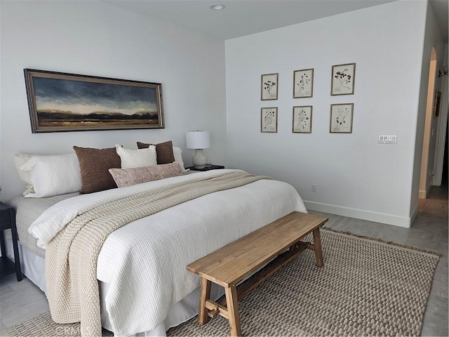 bedroom featuring arched walkways and baseboards