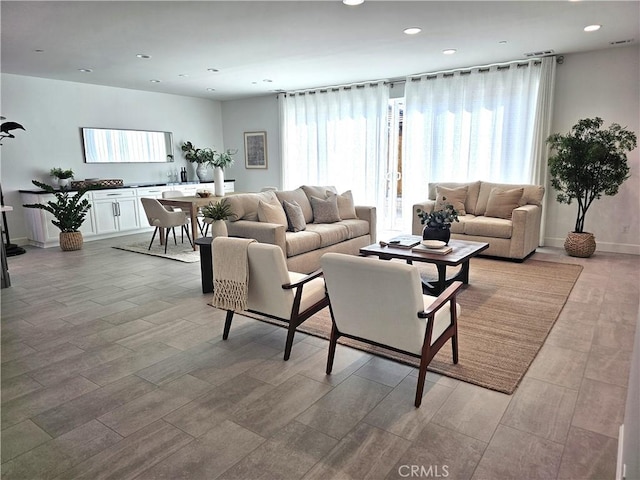 living area with light wood-style flooring, baseboards, and recessed lighting