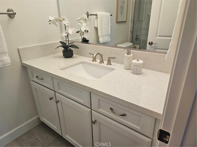 bathroom with tile patterned flooring, an enclosed shower, vanity, and baseboards