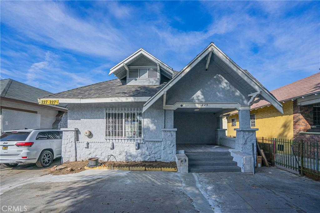 view of front of property featuring roof with shingles, fence, an attached garage, and stucco siding