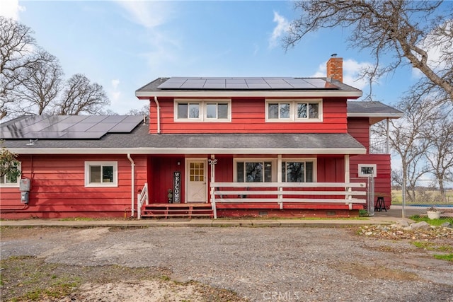 view of front facade with solar panels and a porch