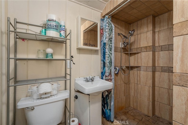 bathroom with curtained shower, toilet, and sink