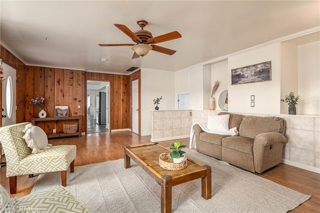 living room featuring hardwood / wood-style flooring, crown molding, and ceiling fan