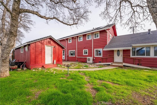 back of house with ac unit and a yard