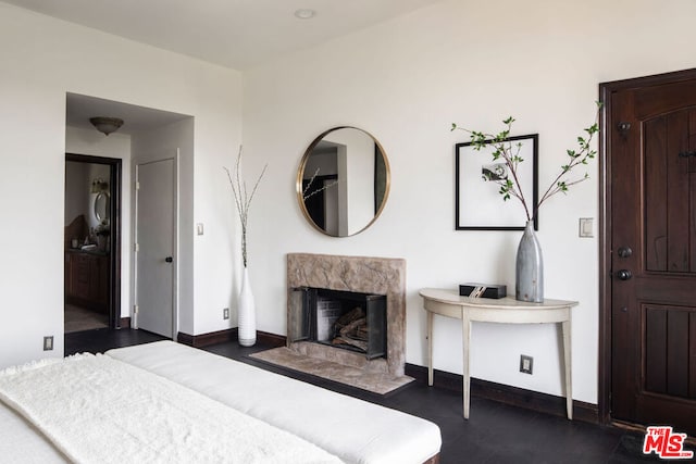 bedroom with dark wood-type flooring and a fireplace