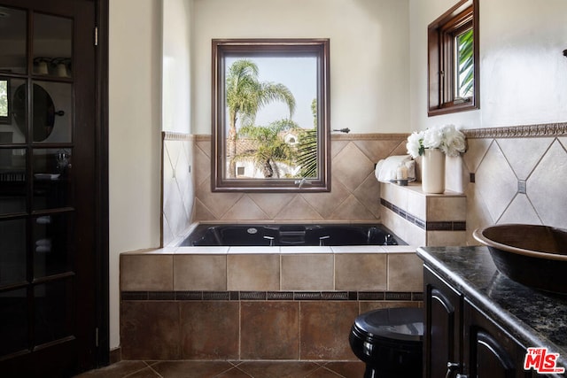 bathroom featuring vanity, tiled bath, and tile patterned flooring