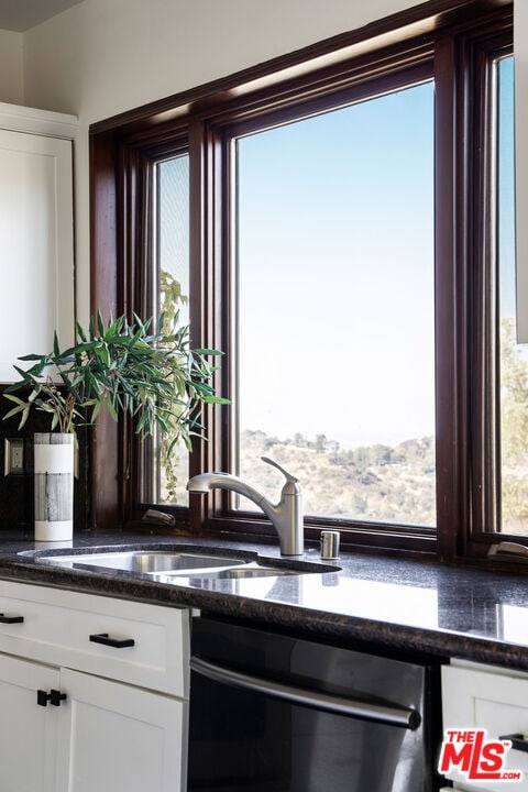 kitchen with sink, white cabinetry, dishwasher, and dark stone counters