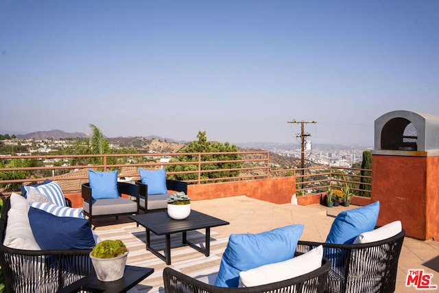 view of patio featuring a mountain view, an outdoor living space, and a balcony