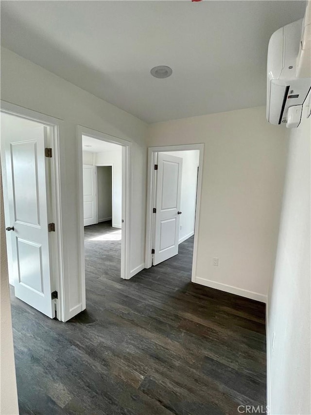 hall with dark hardwood / wood-style floors and a wall unit AC