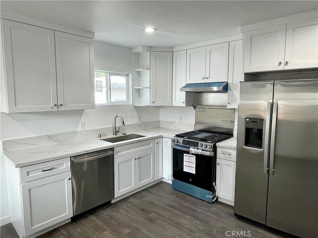 kitchen with sink, light stone counters, appliances with stainless steel finishes, dark hardwood / wood-style flooring, and white cabinets