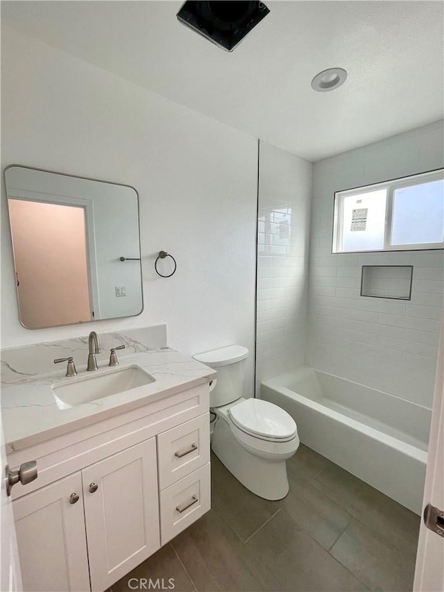 full bathroom featuring tiled shower / bath, vanity, and toilet