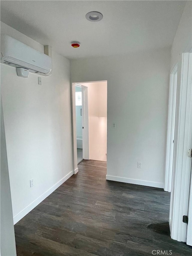 empty room with dark wood-type flooring and a wall unit AC