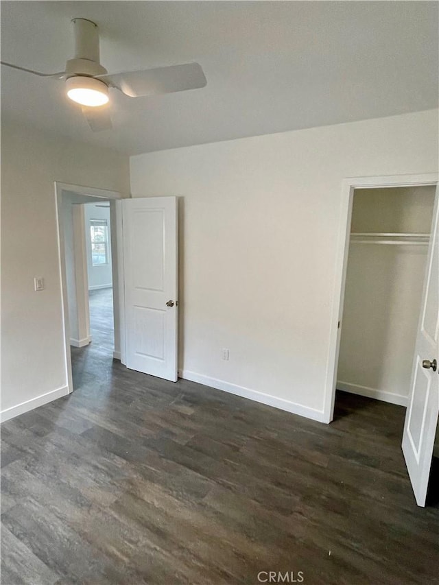 unfurnished bedroom with dark wood-type flooring, ceiling fan, and a closet