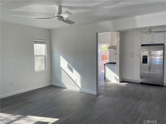 interior space with ceiling fan, dark wood-type flooring, stainless steel fridge, and white cabinets