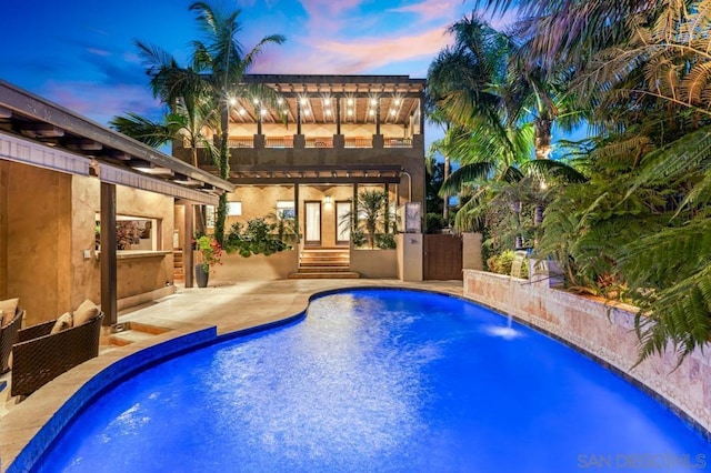 pool at dusk with a patio