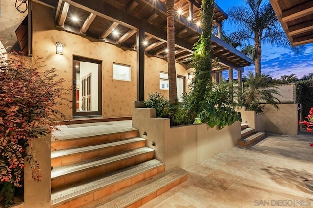 exterior entry at dusk with a patio area