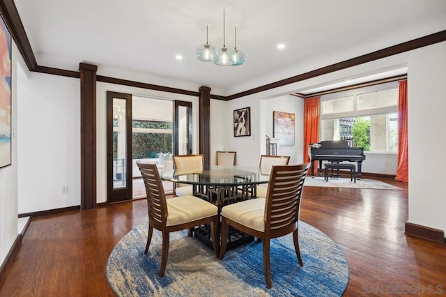 dining space with dark hardwood / wood-style flooring and ornamental molding