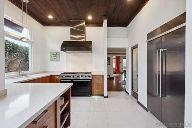 kitchen with wooden ceiling, pendant lighting, premium appliances, and wall chimney range hood