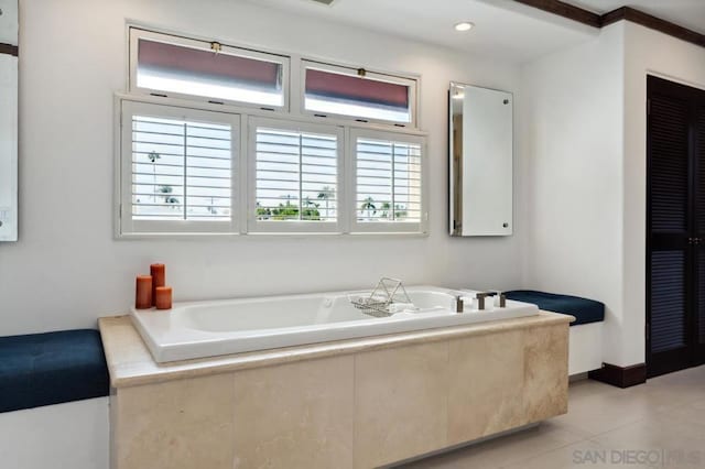 bathroom with tiled tub and tile patterned floors