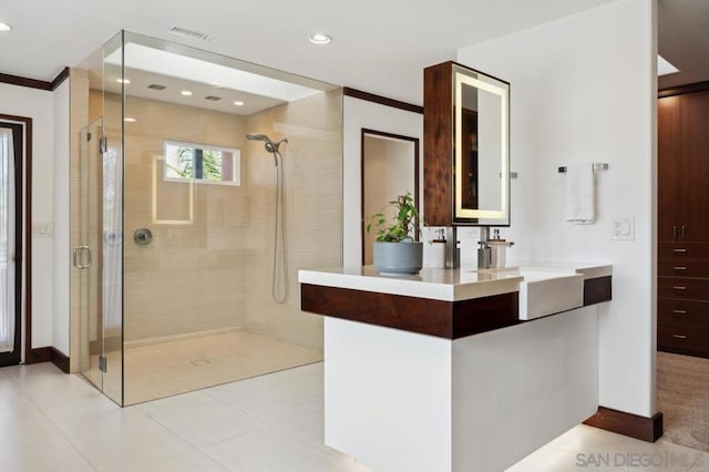 bathroom featuring vanity, ornamental molding, tile patterned floors, and a shower with door