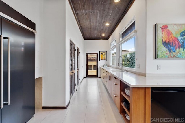 hall featuring wood ceiling, sink, crown molding, and light tile patterned flooring