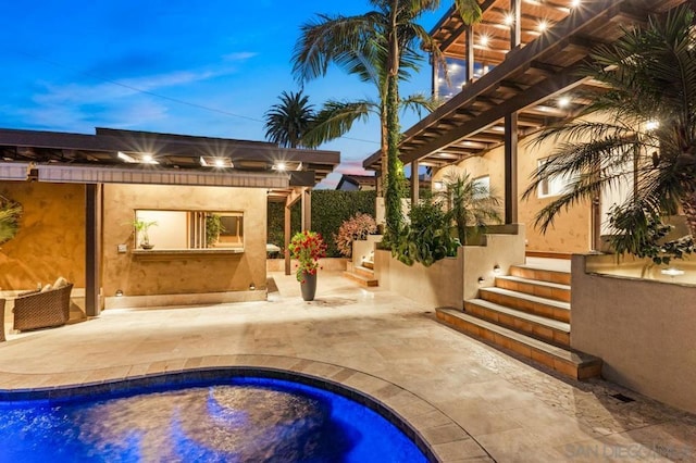 pool at dusk featuring a patio area