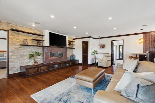 living room featuring a fireplace, dark hardwood / wood-style flooring, and ornamental molding