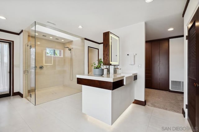 bathroom featuring a shower with shower door, vanity, tile patterned floors, and ornamental molding