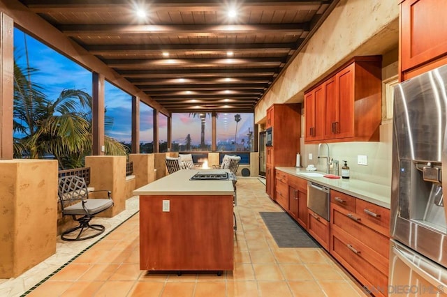 kitchen featuring light tile patterned floors, stainless steel appliances, sink, and a center island