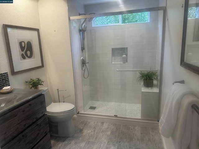 bathroom featuring walk in shower, vanity, and toilet