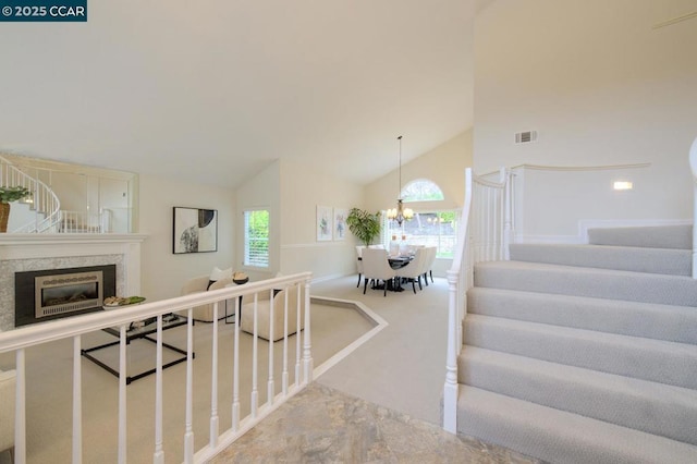 interior space featuring a notable chandelier, high vaulted ceiling, and a healthy amount of sunlight