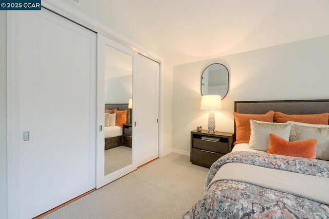 bedroom with light colored carpet and a closet