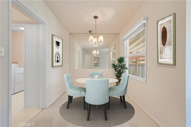 carpeted dining room with washer / clothes dryer and a notable chandelier