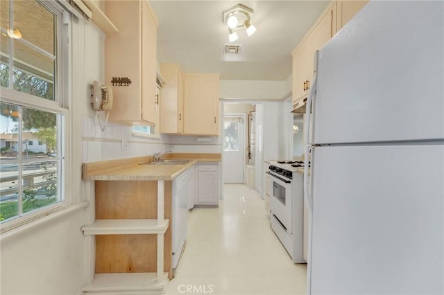 kitchen with wooden counters, sink, and white appliances