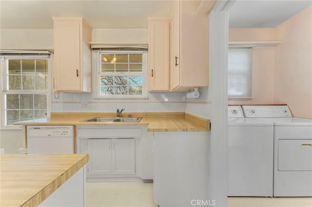 kitchen featuring separate washer and dryer, sink, backsplash, and dishwasher