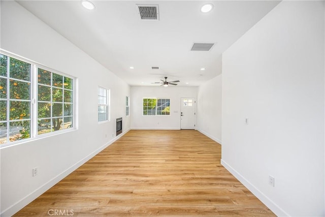 unfurnished room featuring ceiling fan, light hardwood / wood-style flooring, and a wealth of natural light