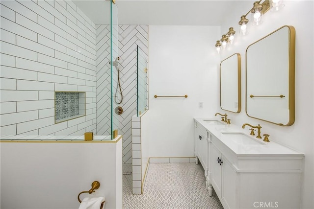 bathroom with vanity, a tile shower, and tile patterned floors