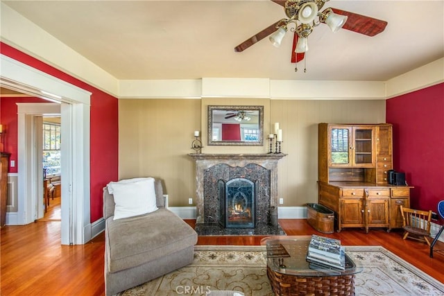 living room featuring hardwood / wood-style floors, a fireplace, and ceiling fan